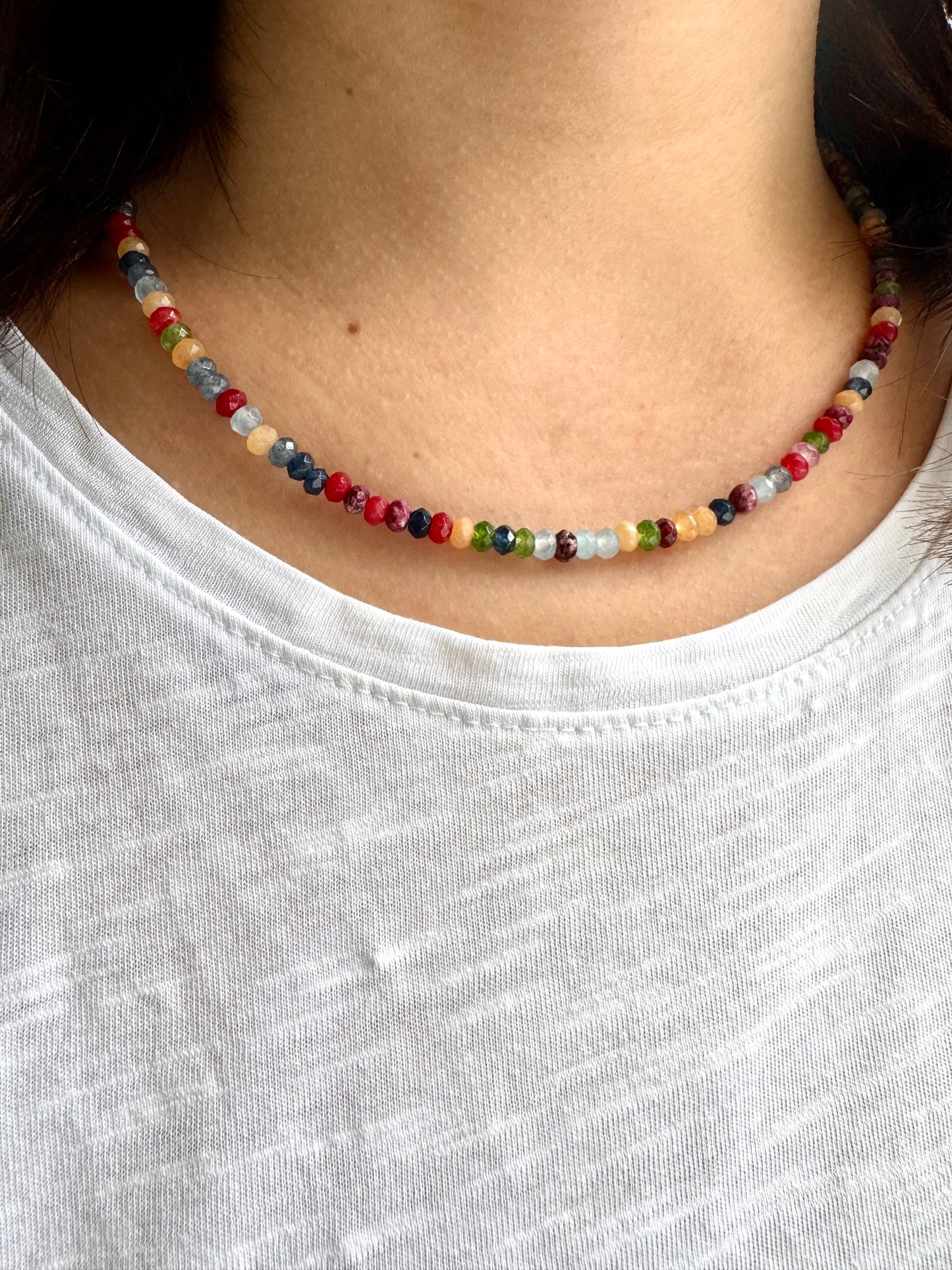 Facettierte bunte Edelstein-Halskette als Close-up getragen, feine Rundperlen in leuchtenden Farben am Hals
