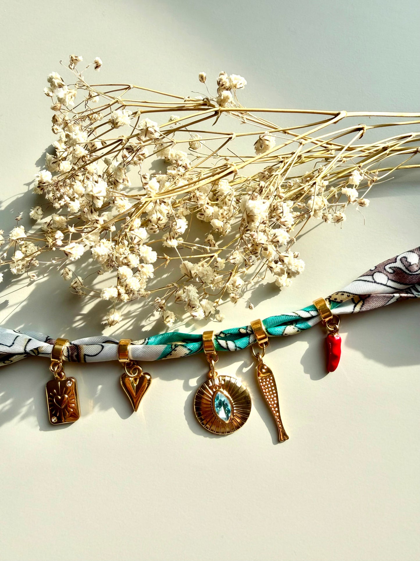 Charm bandana with gold pendants in a turquoise-brown mix • Eye-catching with symbols &amp; crystal detail